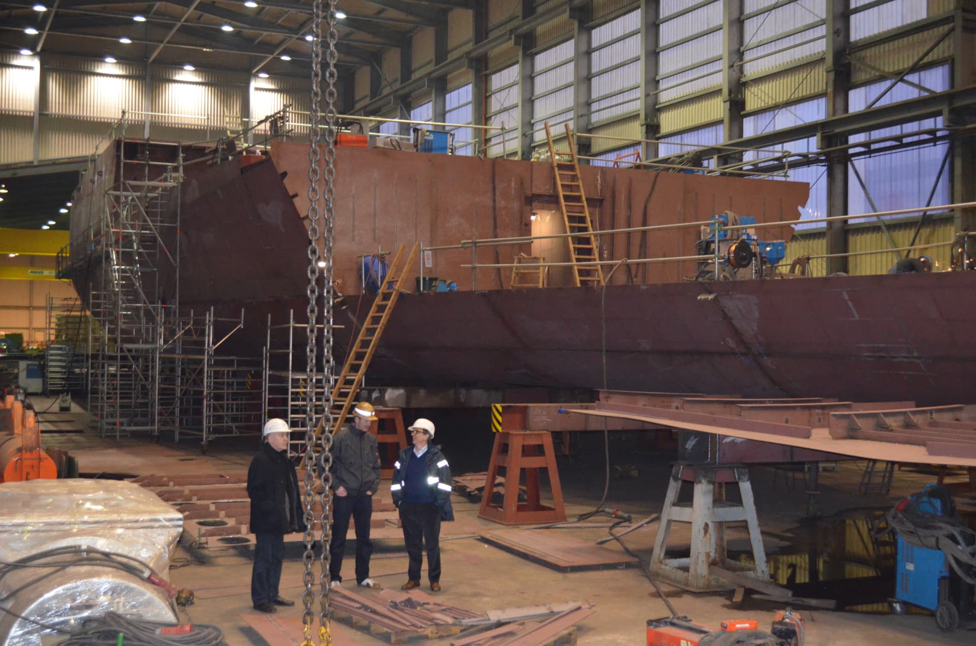 Shipyard team inspecting a hull section inside the construction hall